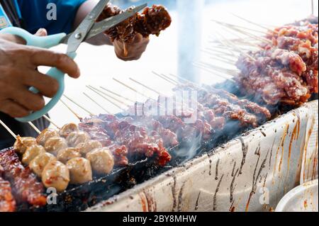 Die leckeren bbq Porks Grillen auf offenem Grill, Küche im Freien, leckeres Essen Braten auf Holzkohlofen mit dem Dipping Thai Stil, die lokale Straße fo Stockfoto