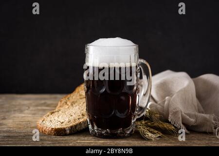 Traditionelle kvass Bierkrug mit Roggenbrot auf Holztisch Stockfoto