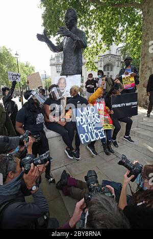 Die Menschen versammeln sich während einer Kundgebung an der Nelson Mandela Statue auf dem Parliament Square, London, um George Floyd zu gedenken, als seine Beerdigung in den USA nach seinem Tod am 25. Mai in Polizeigewahrsam in der US-Stadt Minneapolis stattfindet. Stockfoto