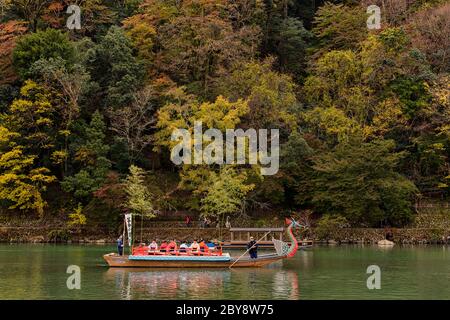 Kyoto / Japan - 12. November 2017: Menschen genießen traditionelle Bootsfahrt auf dem Katsura Fluss in der Nähe des Arashiyama Park in Kyoto, Japan Stockfoto