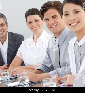 Internationale Geschäftsleute, die an einem Konferenztisch sitzen Stockfoto