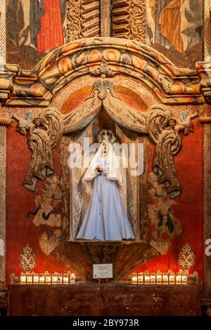 Geschnitzte & bemalte Holztafel mit Jungfrau Maria, Kerzen, Mission San Xavier del Bac (gegründet 1700, aktuelle Struktur 1797), Tucson, Arizona USA Stockfoto