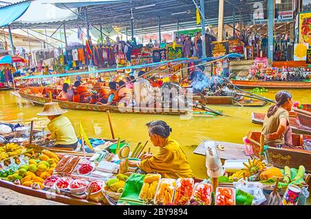 DAMNOEN SADUAK, THAILAND - 13. MAI 2019: Das Sampan-Boot dient als Schaufenster und Theke für den Obsthändler und bietet eine Vielzahl exotischer Früchte i Stockfoto