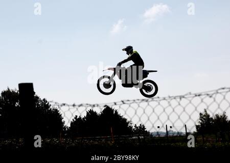 Ein Motocross-Bike springen und es scheint, dass es eine eiserne Linie folgt Stockfoto