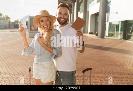 Reisekonzept. Ein Paar zeigt Tickets in der Nähe des modernen Flughafens Stockfoto