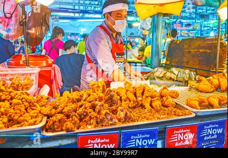 BANGKOK, THAILAND - 13. MAI 2019: Der Stand der Speisen Talad Saphan Phut Markt mit Tabletts von frittierten Hühnchen mit Zwiebeln, am 13. Mai in Bangkok Stockfoto