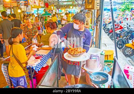 BANGKOK, THAILAND - 13. MAI 2019: Der Koch des Talad Saphan Phut Marktes macht das würzige, frittierte Huhn am 13. Mai in Bangkok Stockfoto