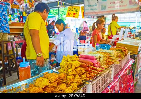 BANGKOK, THAILAND - 13. MAI 2019: Der Markt bietet frittiertes Schweinefleisch auf Spiessen, knusprige Wraps, Würstchen und andere Lebensmittel, Talad Saphan Phut Stockfoto