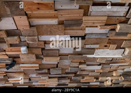 Abstrakt geformte Grunge Hintergrund aus zurückgewonnenen Holzplanken und Bretter mit rauen zerkratzten und beschädigten Oberflächen. Deckendekorationen im Loft Stockfoto