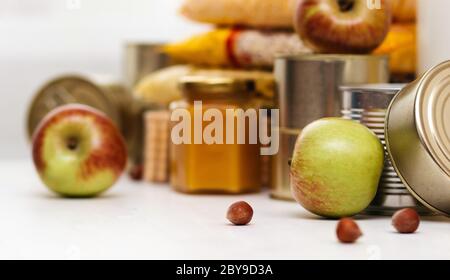 Verschiedene Konserven, Pasta und Getreide auf einem weißen Tisch. Konzept für Lebensmittelspende oder Lebensmittelzustellung Stockfoto