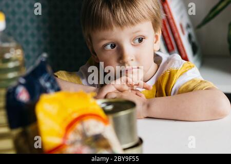 Trauriges Kind im Hintergrund Lebensmittelspende oder Lebensmittellieferungskonzept Stockfoto