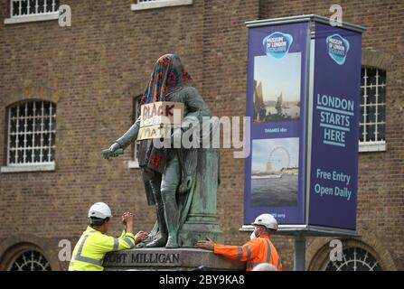 Arbeiter bereiten sich darauf vor, eine Statue des Sklavenbesitzers Robert Milligan am West India Quay, East London, abzubauen, während die Labour Councils in ganz England und Wales beginnen, Denkmäler und Statuen in ihren Städten zu überprüfen. Nach einem Protest wurden in Bristol die Statue eines Sklavenhändlers von Anti-Rassismus-Aktivisten niedergerissen. Stockfoto