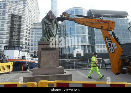 Arbeiter bereiten sich darauf vor, eine Statue des Sklavenbesitzers Robert Milligan am West India Quay, East London, abzubauen, während die Labour Councils in ganz England und Wales beginnen, Denkmäler und Statuen in ihren Städten zu überprüfen. Nach einem Protest wurden in Bristol die Statue eines Sklavenhändlers von Anti-Rassismus-Aktivisten niedergerissen. Stockfoto