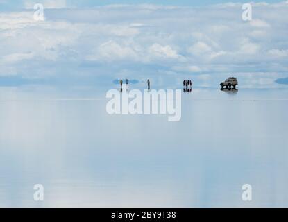 Silhouetten von Reisenden, die sich im Wasser spiegeln Stockfoto