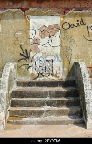 Stufen führen zu Graffiti bedeckten Betonwand Stockfoto