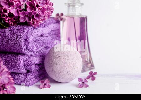 Lila Blüten, aromatische Meersalzbirne, lila Duft und Handtücher. Konzept für Spa, Beauty-und Health-Salon, Kosmetik-Shop. Nahaufnahme Foto auf weiß Stockfoto