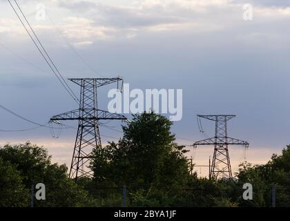 Säule und Stromleitungen gegen einen bewölkten Himmel 3 Stockfoto