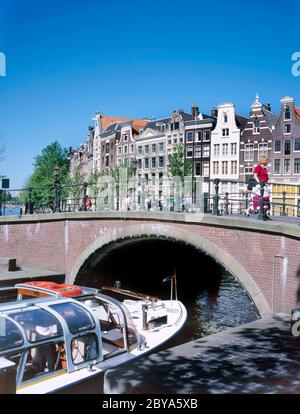 Amsterdam, Holland-08. Mai 2020; Kanalboot unter den Brücken eines Kanals in Amsterdam Niederlande, Holland, EU, Europa Stockfoto