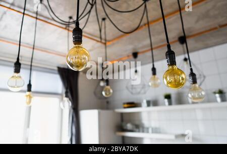 Große Vintage Glühbirnen hängen in der modernen Küche. Dekorative antike edison Glühbirnen mit geradem Draht. Ineffizientes Glühwendellicht Stockfoto