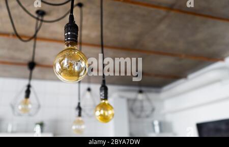 Dekorative antike edison Glühbirnen mit geradem Draht. Große Vintage Glühbirnen hängen in der modernen Küche. Ineffizientes Glühwendellicht Stockfoto