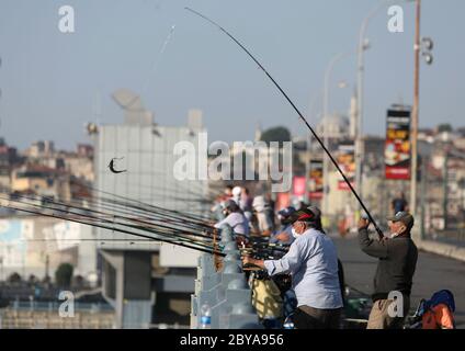 Istanbul, Türkei. Juni 2020. Am 9. Juni 2020 wird auf der Galata-Brücke in Istanbul, Türkei, gefischt. Die alte Brücke im historischen Herzen der größten türkischen Stadt Istanbul am Dienstag ist voller Angler und wirft Bedenken der türkischen Regierung und der lokalen Behörden über die Verbreitung von COVID-19 auf. Nachdem die Regierung letzte Woche die COVID-19-Beschränkungen gelockert hatte, strömten täglich mehr als 500 Fischer zur Galata-Brücke, einem Hotspot-Angelort im europäischen Teil der Stadt, die das Goldene Horn überspannt. Kredit: Osman Orsal/Xinhua/Alamy Live News Stockfoto