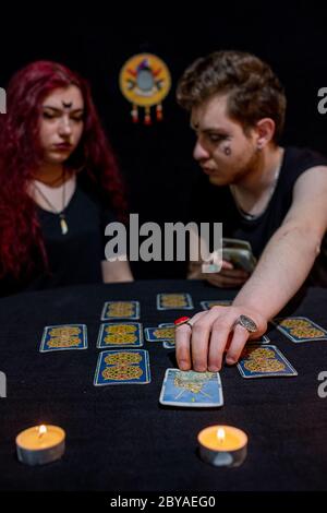 Wahrsager mit Tarot-Karten auf schwarzem Hintergrund Stockfoto