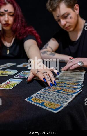 Wahrsager mit Tarot-Karten auf schwarzem Hintergrund Stockfoto