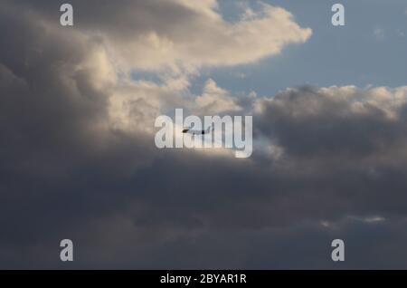 FLUG 419: Kommerzielle Flugzeuge starten von einem nahe gelegenen Newark International Airport in New Jersey in die untergehende Wolkenlandschaft an einem Frühlingstag. Stockfoto