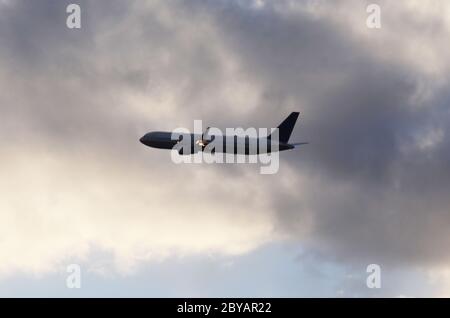 FLUG 419: Kommerzielle Flugzeuge starten von einem nahe gelegenen Newark International Airport in New Jersey in die untergehende Wolkenlandschaft an einem Frühlingstag. Stockfoto