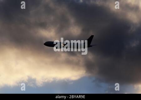 FLUG 419: Kommerzielle Flugzeuge starten von einem nahe gelegenen Newark International Airport in New Jersey in die untergehende Wolkenlandschaft an einem Frühlingstag. Stockfoto