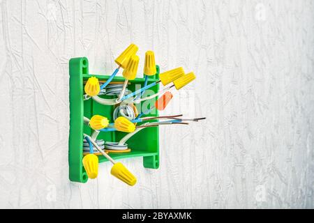 Drahtmuttern zum Verdrehen von Haushaltskabeln. Anschlussdose mit den Enden der Kupferdrähte. Verteilertafel im elektrischen System des Hauses an der Th Stockfoto