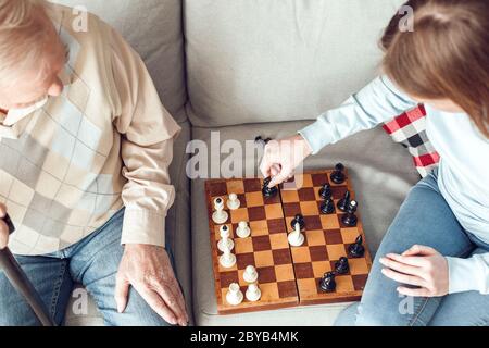 Vater und Tochter zu Hause Bibliothek sitzen Schach spielen Draufsicht Stockfoto