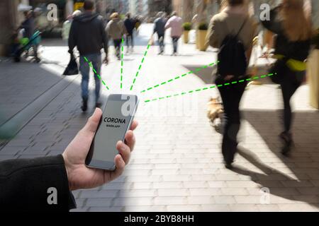 Smartphone mit der Corona Warn App verbindet die Anwendung zur Verfolgung oder Verfolgung von Kontakten gegen die Covid 19-Pandemie andere Telefone von beweglichen Personen Stockfoto