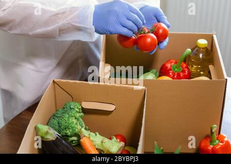 Lieferung von Waren zum Mitnehmen und zur Tür. Kommissionierer in Schutzanzug, Handschuhen und Maske bestellen. Coronavirus-Pandemie (COVID-19). Online-Kontra Stockfoto