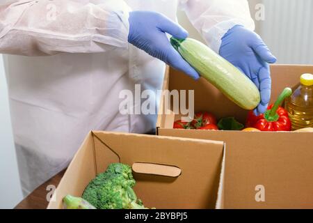 Lieferung von Waren zum Mitnehmen und zur Tür. Kommissionierer in Schutzanzug, Handschuhen und Maske bestellen. Coronavirus-Pandemie (COVID-19). Online-Kontra Stockfoto