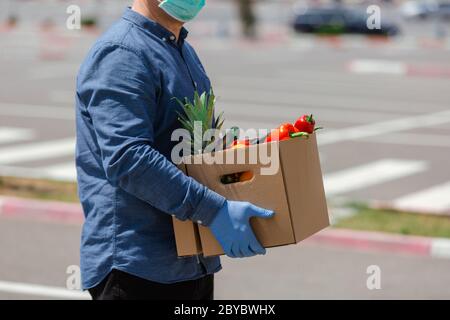 Kurier mit medizinischen Handschuhen liefert Essen zum Mitnehmen. Lieferdienst unter Quarantäne, Krankheitsausbruch, Coronavirus covid-19 Pandemie conditio Stockfoto