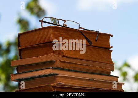 Stapel alter Bücher mit Gläsern. Stockfoto