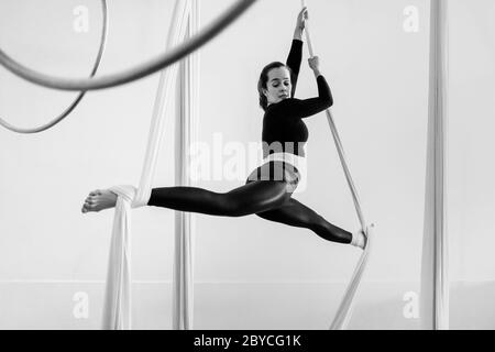 Eine kolumbianische Lufttänzerin tritt während einer Trainingseinheit in einem Fitnessstudio in Medellín, Kolumbien, auf Luftseiden auf. Stockfoto