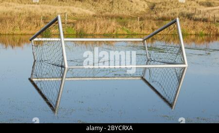 Fußballtor in einem überschwemmten Feld Stockfoto