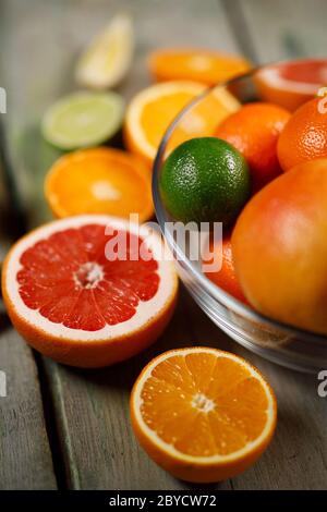 Frische und gesunde Zitrusfrüchte auf alt bemaltem Holztisch mit Akzent auf roter Grapefruit Stockfoto