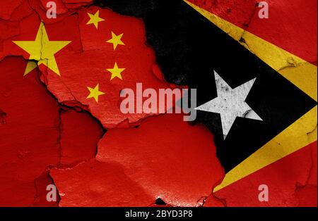 Flaggen von China und Osttimor auf rissige Wand gemalt Stockfoto