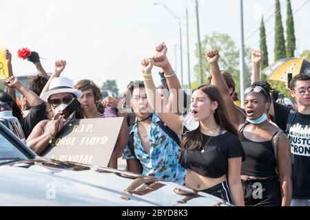 Demonstranten entlang der Strecke von George Floyds Trauerzug zollen ihren Respekt mit erhobener Fäuste und Anti-Polizei-Brutalität Gesängen. Der Tod von Floyd, der Ende Mai von einem weißen Polizisten getötet wurde, löste weltweit Proteste gegen Rassismus und Polizeibrutalität aus. Stockfoto