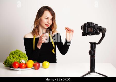 Eine junge Frau in lightroom schreibt einen Blog über Gewichtsverlust und gesunde Ernährung Stockfoto