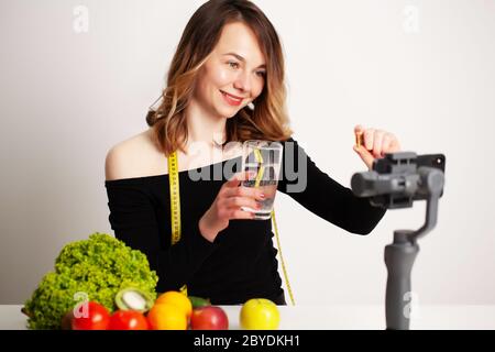 Eine junge Frau in lightroom schreibt einen Blog über Gewichtsverlust und gesunde Ernährung Stockfoto