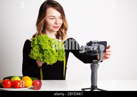 Eine junge Frau in lightroom schreibt einen Blog über Gewichtsverlust und gesunde Ernährung Stockfoto