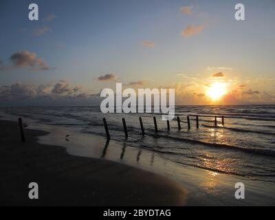 Sonnenaufgang im Wasser und im Sand, Packery Channel Jetty Beach, Padre Island, Texas, Konzept für Urlaubsziel, Tourismus, Strände Stockfoto