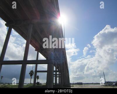 Ein perspektivischer Blick von unterhalb einer Brücke über die Laguna Madre, die das Festland von Corpus Christi, Texas verlässt und zur Padre Island hinübergeht Stockfoto