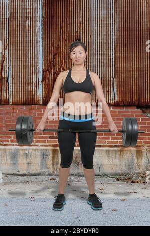 Asiatische Frau, die Arbeit mit Gewichten Stockfoto