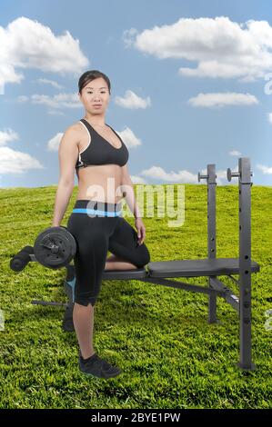 Asiatische Frau, die Arbeit mit Gewichten Stockfoto