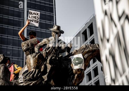 Junge Männer klettern Statue am BLM Protest, King George Square Stockfoto